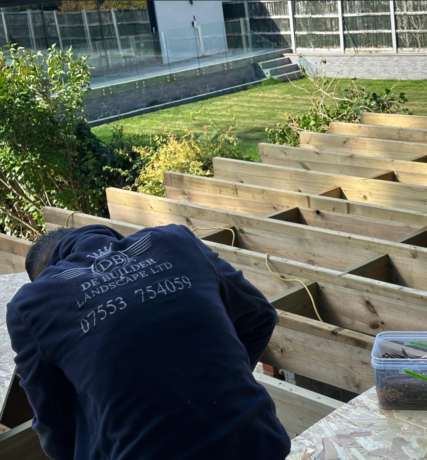 De Builder & Landscape team member constructing timber deck framework on site